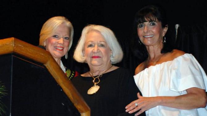 贝蒂·瑟拉什和两个女人站在领奖台上